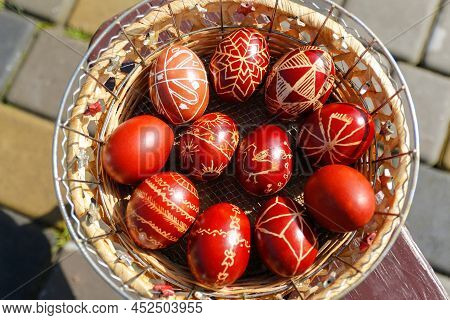 Defocus Closeup Of Basket Of Colored Red Eggs, Easter Holiday Concept. Modern Painted Easter Eggs. N