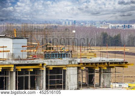 Monolithic Frame Construction Of The Building. Workers Working At The Construction Site At Home. The