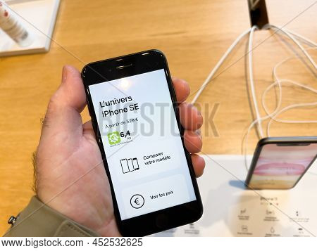 Paris, France - Ap 7, 2022: Male Hand Holding New Latest Apple Computers Iphone Se Smartphone With C