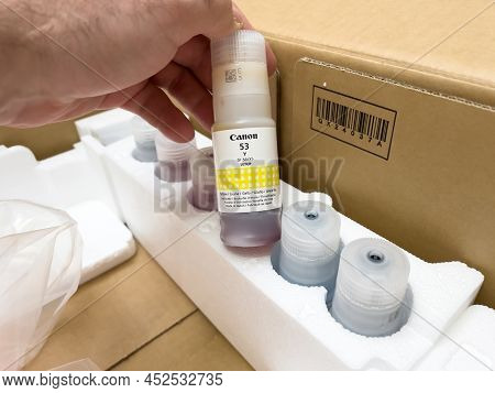 London, United Kingdom - Ap 3, 2022: Holding Ink Bottle Canon 53 Y For Pixma G550 Single Function Pr