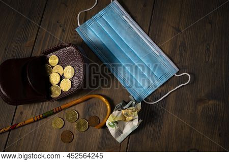 Conceptual Covid-19 Flat Lay Still Life With Money Spilling From An Open Purse Onto A Wooden Table W