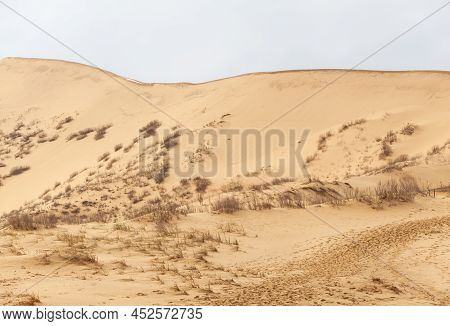 Sarykum Dune. Dagestan, Russia. A Unique Sandy Mountain In The Caucasus On A Cloudy Day. Grass Grows