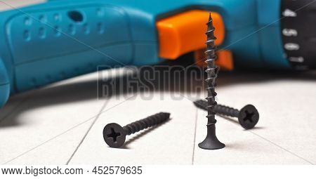 Screwdriver And Screws Lie On A Sheet Of Drywall. The Gypsum Sheet Is Marked With A Pencil. Building