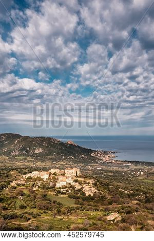 Hilltop Village Of Pigna In The Balagne Region Of Corsica With Mediterranean Sea In The Distance