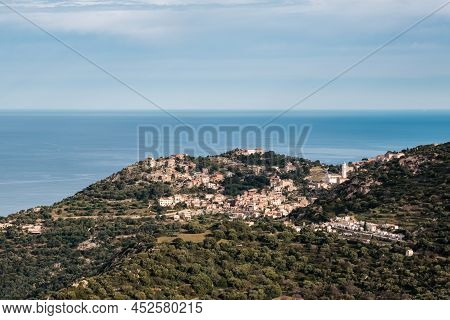 Hilltop Village Of Corbara In The Balagne Region Of Corsica With Mediterranean Sea In The Distance