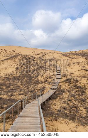 The Staircase Rises To A Sandy Dune. Climbing To The Top In The Desert. Sarykum Dune. Dagestan, Russ