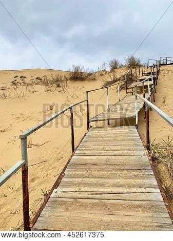 The Staircase Rises To A Sandy Dune. Climbing To The Top In The Desert. Sarykum Dune. Dagestan, Russ