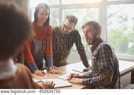 Businessman And A Group Of Employees Discussing Business Documen