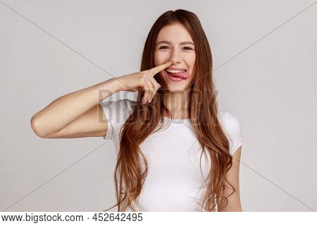Funny Cheerful Woman Picking Nose With Stupid Silly Face, Pulling Out Boogers, Bad Manners Concept, 