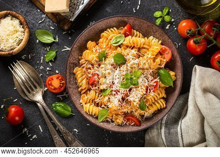 Italian Pasta Alla Arrabiata With Basil, Tomato And Parmesan On Dark Table. Top View Image.