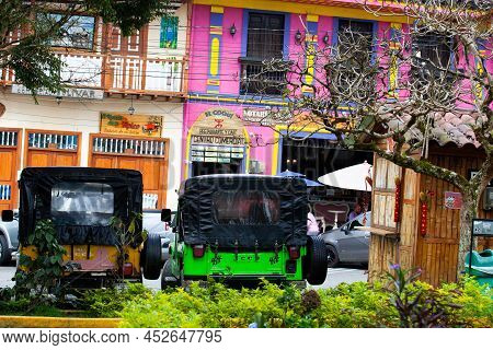 Salento, Colombia - July 2021. Traditional Jeeps Willy Parked At The Main Square Of The Beautiful Sm