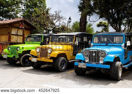 Salento, Colombia - July 2021. Traditional Jeeps Willy Parked At The Main Square Of The Beautiful Sm