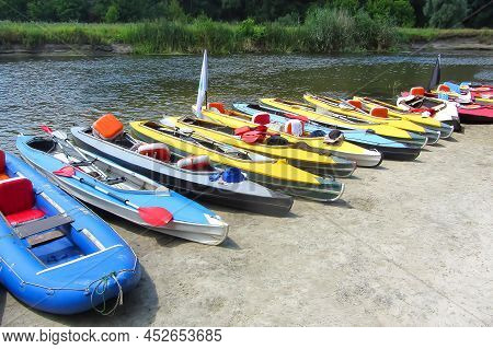 A Kayak Stand Near The Bank Of The River On A Summer Sunny Day