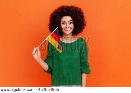 Portrait Of Attractive Positive Woman With Afro Hairstyle Wearing Green Casual Style Sweater Holding
