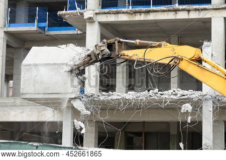Excavator Machine With Hydraulic Crashers At Demolition Of The House. House Being Demolished By Spec
