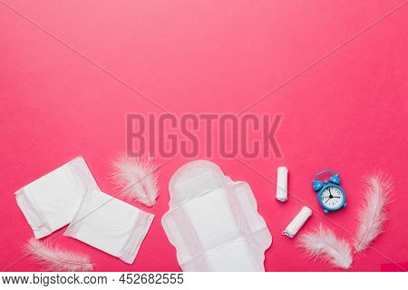 Ringing Alarm Clock With Sanitary Female Tampons And Menstrual Sanitary Pads. Medical Concept Of Wom