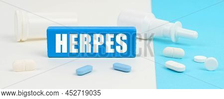 Medical Concept. On A White And Blue Surface Are Pills, A Spray And A Wooden Sign With The Inscripti