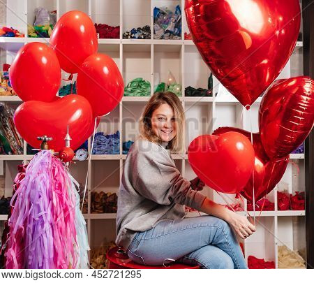 Woman On Red Decorative Barrel. With A Large Red Balloons In The Shape Of Heart.