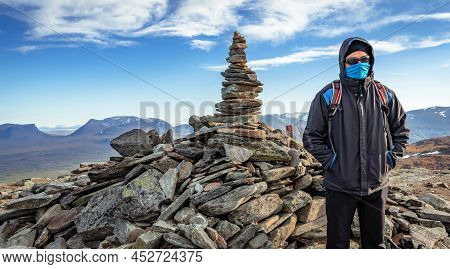 Male Hiker Standing On The Top Of Nuolja, Or Njulla, Mountain In Abisko National Park In Arctic Swed
