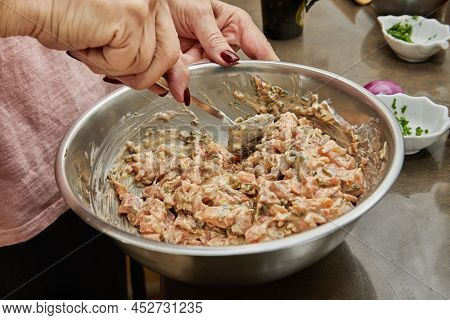 Chef Stirs Salmon Dish In Bowl With Spoon