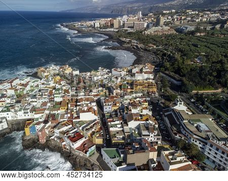 Aerial View On Colorful Houses And Black Lava Rocks In Small Village Punta Brava Near Puerto De La C