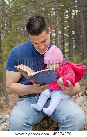 Dad And Baby Daughter Reading Bible