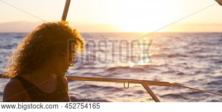 Portrait Of Attractive Middle Age Woman Sitting On The Wooden Deck Of The Yacth Enjoying The Trip - 
