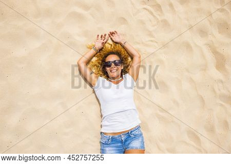 Happy Adult Woman Lay Donw On The Sand Beach Enjoying Summer Sun And Holiday Vacation - One Beautifu