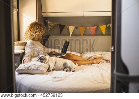 Attractive Woman Have Relax Inside Van Camper Laying On Bed And Using Laptop Computer Connection. Ad