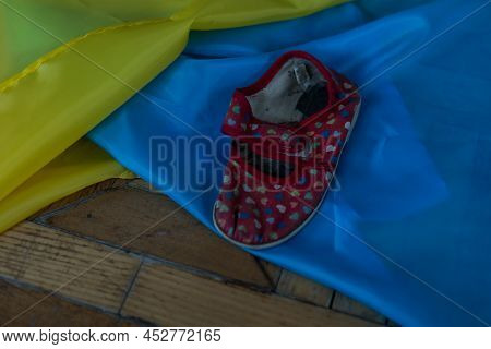 Childrens Shoes And The Flag Of Ukraine, The Warthe War In Ukraine.