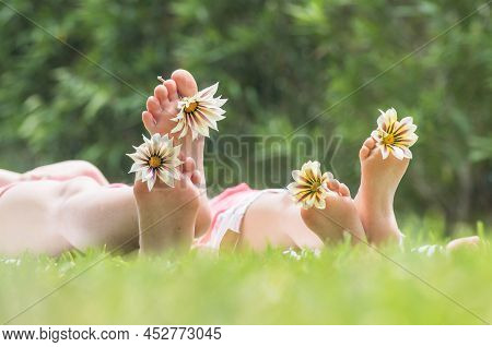 Two Sisters Playing With Daisy Flowers On Grass Outdoors In Thepark, Summertime Fun