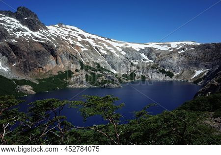 Patagonia nature Alpine lake, Laguna Azul in Nahuel Huapi National Park, Surrounded by granite walls Cerro de las Cristales mountain, Man swimming far on distance, Argentina South America