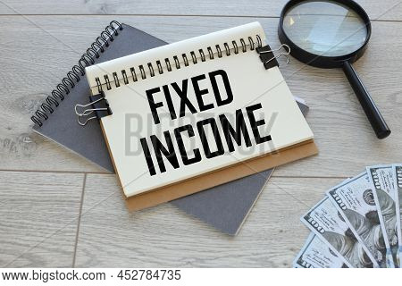 Fixed Income Open Notepad With Text On Gray Notepad Near Magnifier And Money