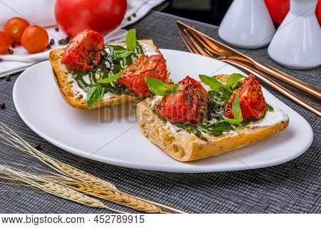 Bruschetta With Tomatoes And Cheese, Pesto Sauce With Basyl On White Plate