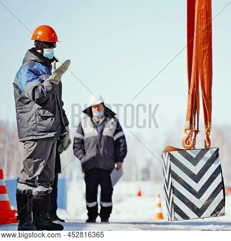 Engineer Takes Exam From Slinger. Worker Gestures To Lift Up Control Load. Training Of Slingers. Aut