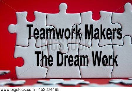 Motivational Text On Jigsaw Puzzle With Red Background - Teamwork Makes The Dream Works. Teamwork An