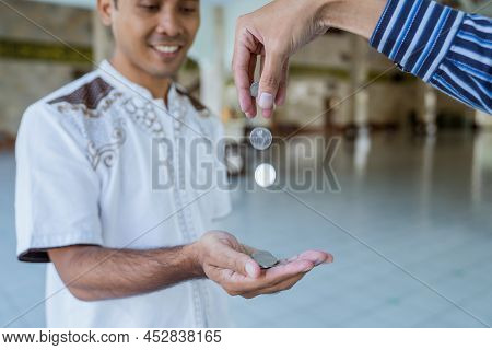 Muslim Paying Some Zakat Charity Using Cash At The Mosque