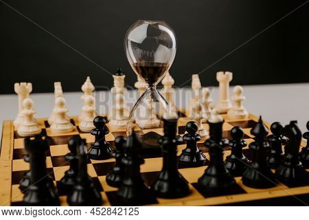 Hourglass On A Chessboard At The Beginning Of The Game. Management Concept