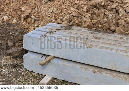 Reinforced Concrete Slabs At A Construction Site Against A Blue Cloudy Sky And Earth. Folded Plates 