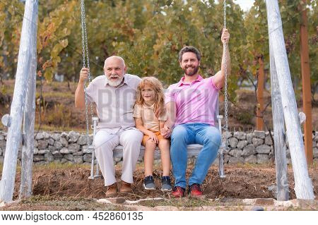 Men Generation Family Playing On Swing Together Three Different Generations Ages: Grandfather Father