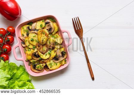 Bacon Tartiflette On A Baking Dish With Herbs And Vegetables At Home On A Wooden White Background. V