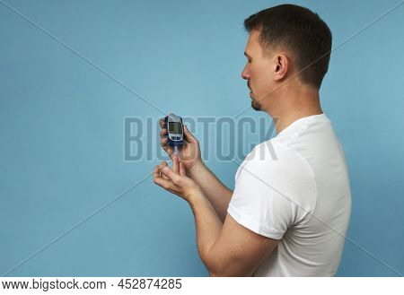 Man Checking Blood Sugar Level With Glucometer. Young Man Doing Diabetes Test