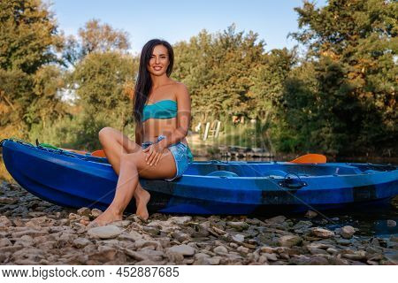 Kayaking. A Beautiful Smiling Tanned Woman In A Poses Sitting On A Kayak. Recretion At The National 