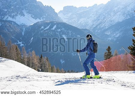 Male Skier Skiing On Landscape By Barrier Against Mountain Range