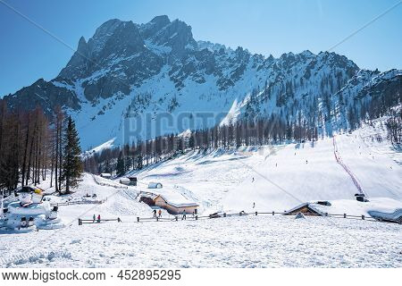 Snowman By Snow Covered House Against Trees On Mountain During Winter In Alps
