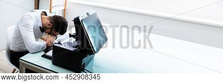 Tired Businessman Resting His Head In Front Of Paper Stuck In Printer