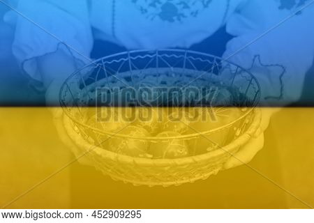 Defocus Female Hands Holding Basket Of Colored Red Eggs On Nature Green Grass Background. Easter Hol