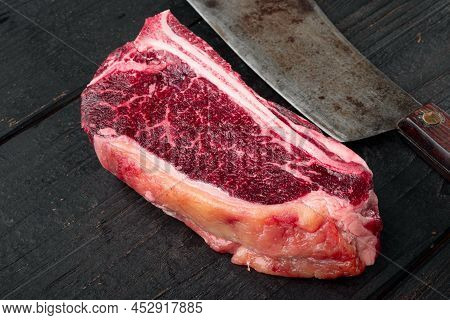 Raw Beef Meat Marbled Dry Aged Club Or Striploin On The Bone Steak Set, On Black Wooden Table Backgr