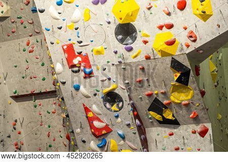 Artificial Rock Climbing Wall With Various Colored Grips.