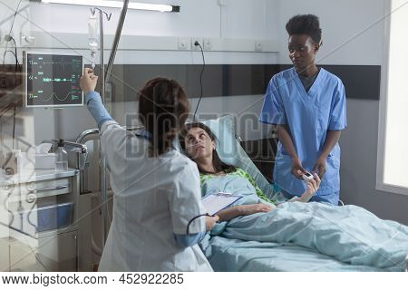 Doctor Setting Up Central Line Catether With Iv Drip Medication To Patient While Nurse Is Putting Pu
